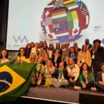 Grupo de pessoas segurando a bandeira do Brasil em um evento internacional