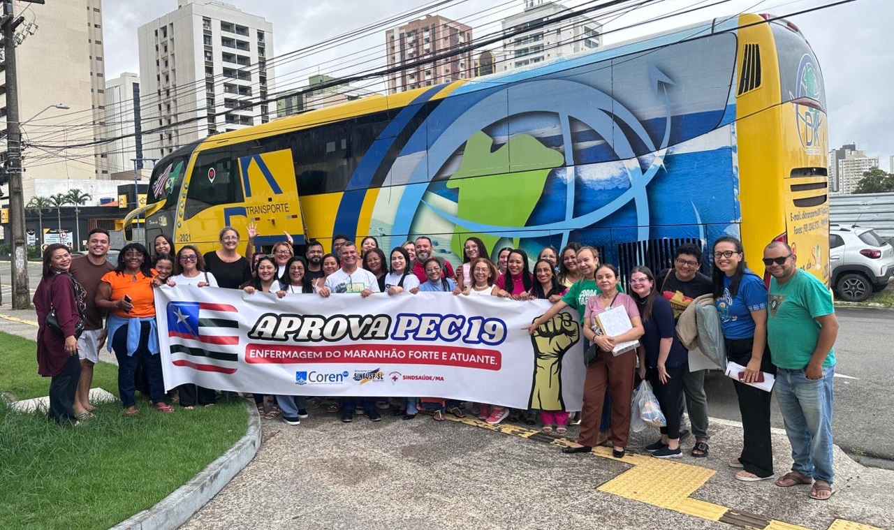 Pessoas em frente ao ônibus com faixa em apoio à PEC 19