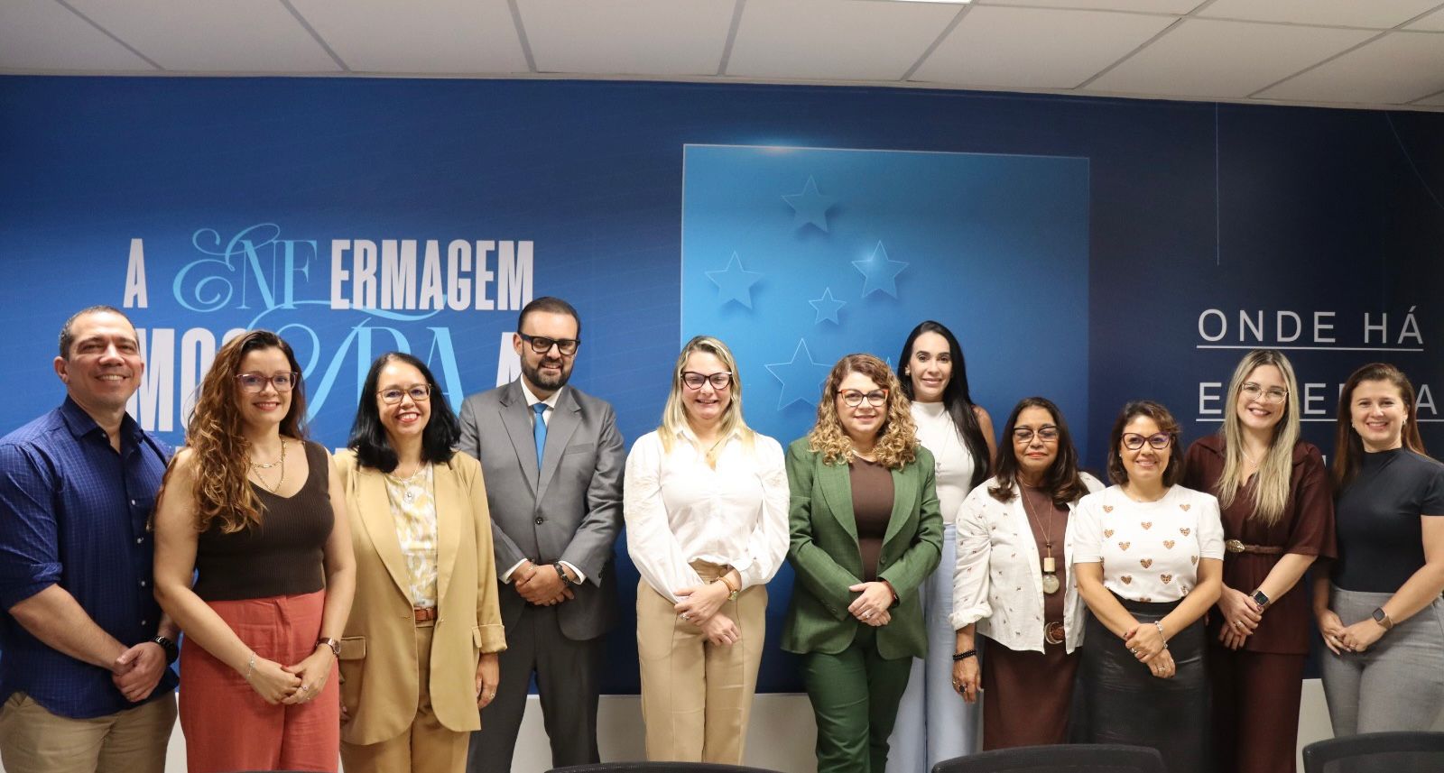 Várias pessoas em pé pousando para foto