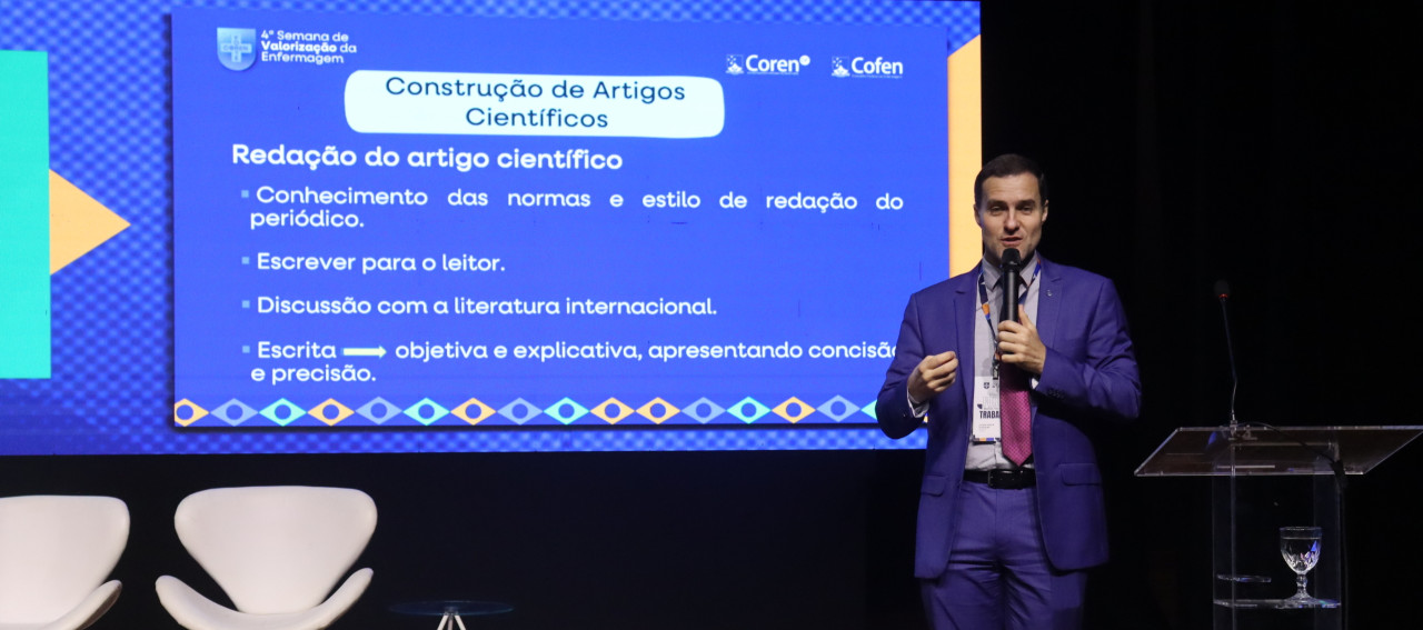 Pessoa em pé no palco de um auditório