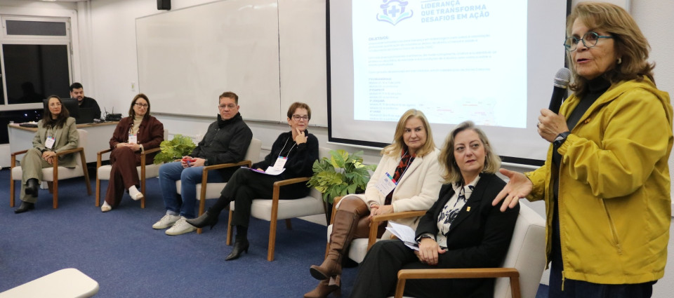 Uma pessoa em pé falando para participantes de um curso