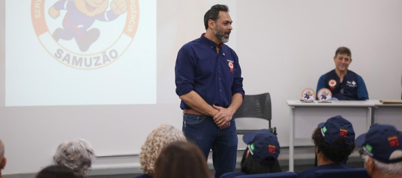 Pessoa em pé falando com alunos em sala de aula