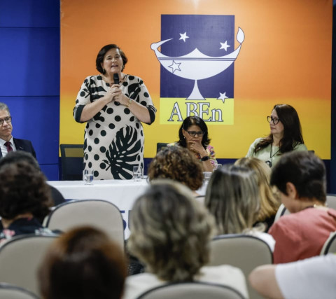 Pessoa em pé falando para pessoas sentadas em um auditório